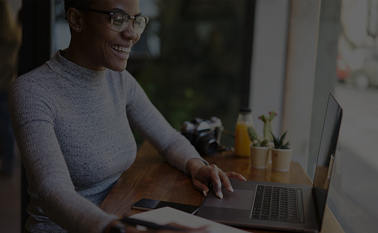 A woman smiling at a laptop